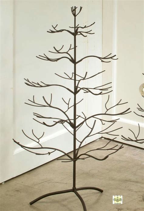 A Metal Tree With No Leaves On It In Front Of A White Wall And Floor