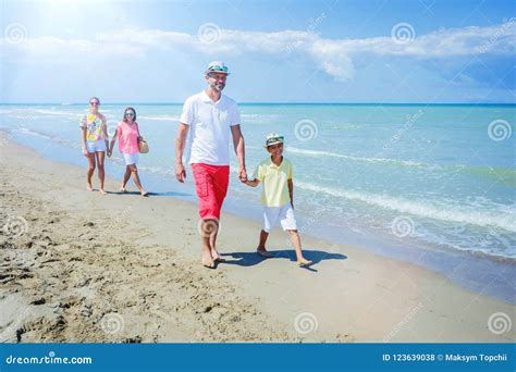 Familia De Cuatro Miembros Que Se Divierte En La Playa Foto De Archivo