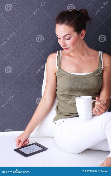 Attractive Caucasian Girl Sitting On Floor With Cup And Tablet Near