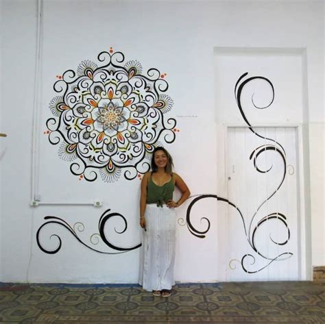 A Woman Is Standing In Front Of A Wall Decoration