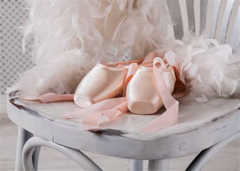 Pink Ballet Pointe Shoes And Feather On White Wood Background Stock