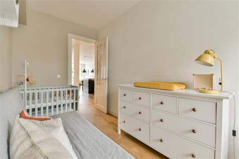 Premium Photo | A nursery with a white dresser and a crib