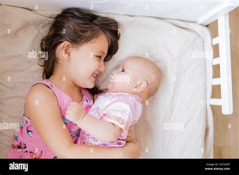 Petite fille en robe sur son lit Banque de photographies et dimages à