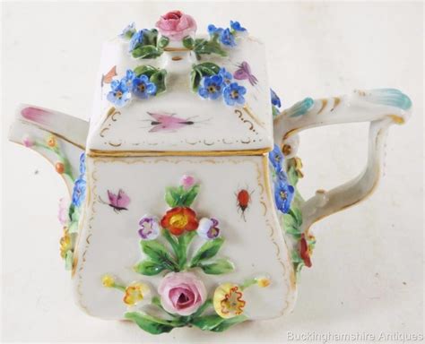 A Tea Pot With Flowers Painted On It