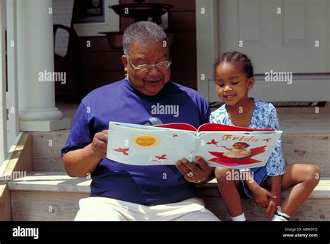 Grandfather Reading To Granddaughter Stock Photo Alamy