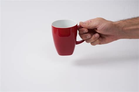 Premium Photo Male Hand Holding A Red Coffee Mug