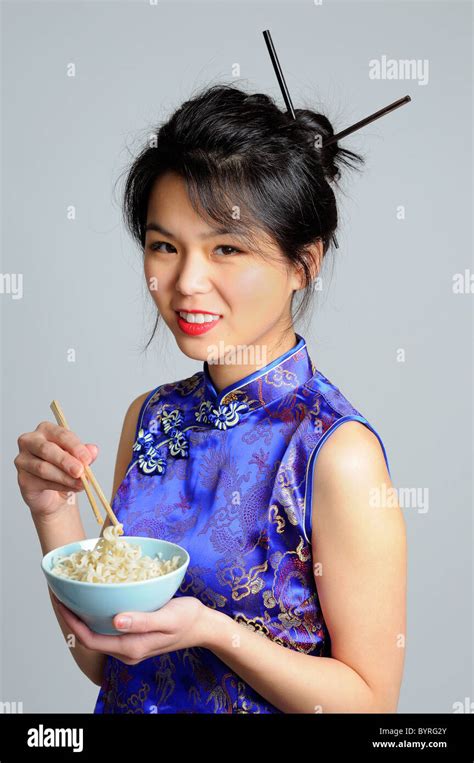 Chinese Woman Dressed In A Traditional Cheongsam Holding A Bowl Of