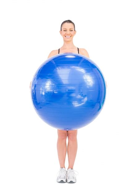 Premium Photo Smiling Fit Woman Holding Exercise Ball In Front Of Her