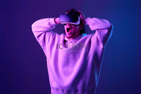 戴着 vr 眼镜和运动衫的男人在蓝色背景上玩耍高清摄影大图 千库网