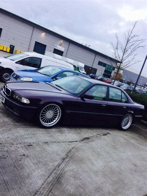 A Purple Car Parked In Front Of A Building