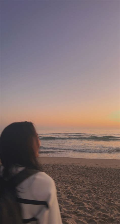 Girl At The Beach During Sunset With Calm Waters And Clear Skies Ahead