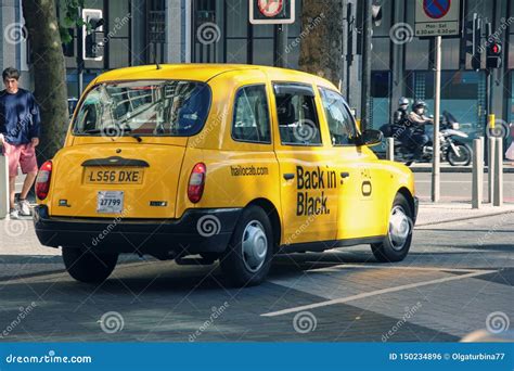 Famous British Yellow Taxi Cab On London Street On Sunny Day Editorial