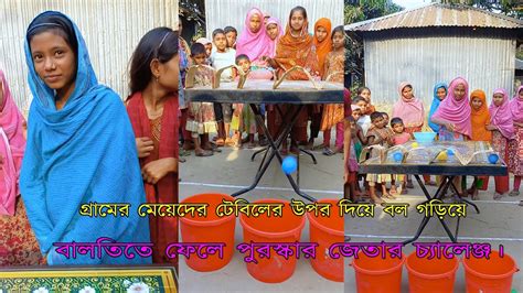 গ্রামের মেয়েদের টেবিলের উপর দিয়ে বল গড়িয়ে বালতিতে ফেলে পুরস্কার