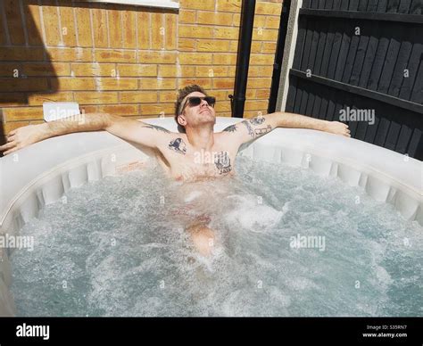 Tattooed Man Enjoying A Soak In An Inflatable Hot Tub Stock Photo Alamy