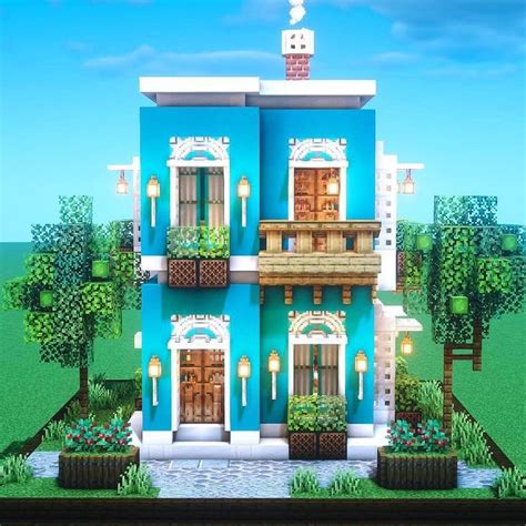 A Large Blue House With Lots Of Windows And Plants On The Front Porch