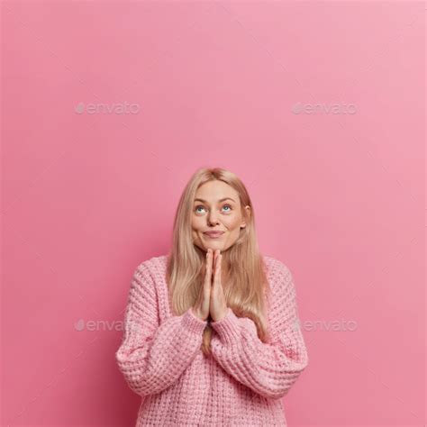 Hopeful European Girl With Blonde Hair Keeps Palms Pressed Together Prays For Good Concentrated