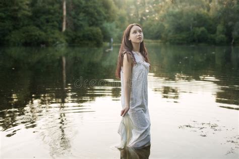 La Femme Dans La Chemise De Nuit Se Baigne Dans Le Lac Photo Stock