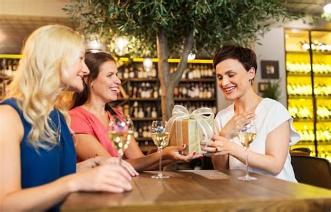 Premium Photo Women Giving Present To Friend At Wine Bar