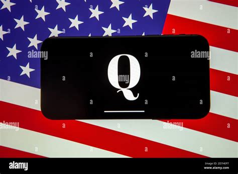 Logotipo de la organización QAnon visto en el smartphone que se coloca