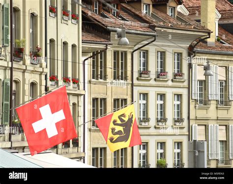 Swiss flag and flag of Bern on the facade building in Bern, Switzerland Stock Photo - Alamy