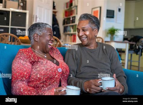 Senior Couple Sitting On Sofa And Drinking Coffee Stock Photo Alamy