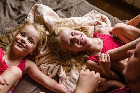 Daddy Has Fun Playing With His Two Daughters In Bikini Suits Painted With Markers At Home