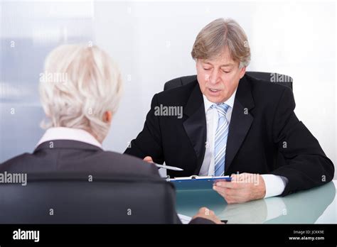 Mature Businessman Discussing With Businesswoman In Meeting Stock Photo
