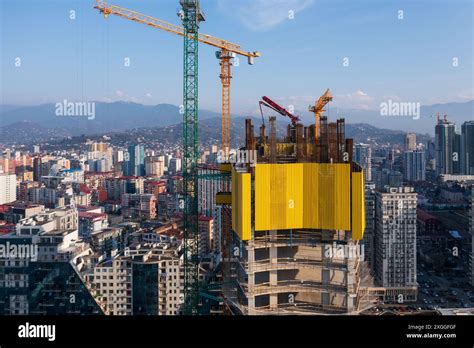 High Rise Building Under Construction With Cranes Set Against Backdrop