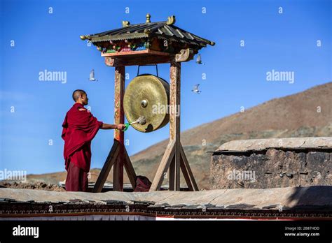 Tibetan Monk Hitting Gong At Ngor Monastery In Shigatse Tibet Stock