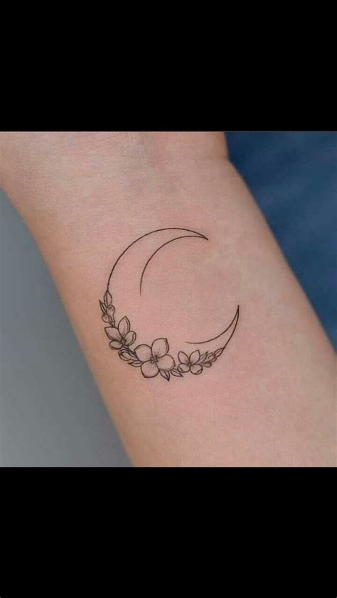 A Woman S Arm With A Flower And Crescent Tattoo On It