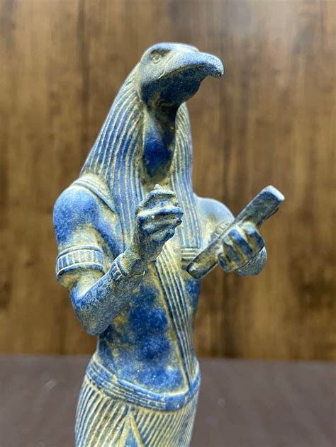 A Statue Of An Egyptian God Holding A Cell Phone