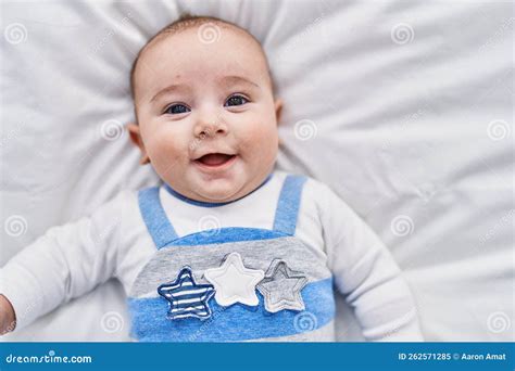 Adorable Baby Smiling Confident Lying On Bed At Bedroom Stock Image