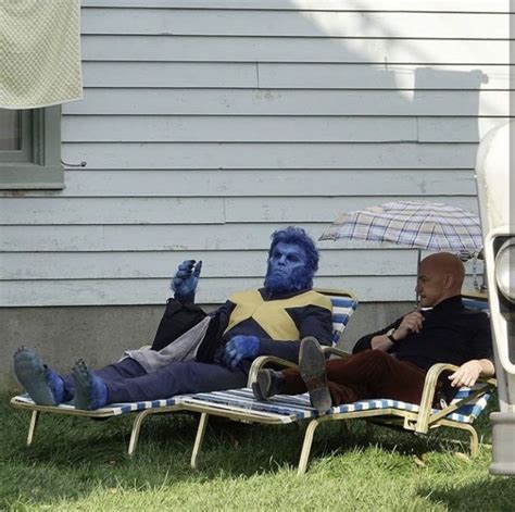 Two People Sitting On Lawn Chairs In Front Of A House