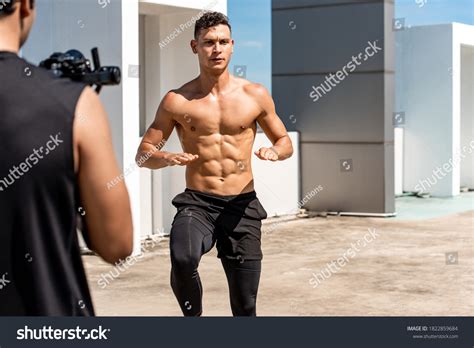 Muscular Man Fitness Influencer Recording Exercise Stock Photo