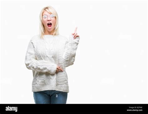 Belle jeune femme blonde portant des lunettes et pull d hiver sur fond isolé montre de l index