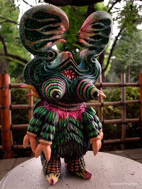 An Artisticly Decorated Bird Statue Sitting On Top Of A Cement Slab In