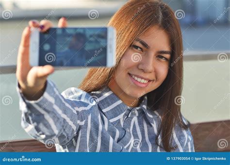 Portrait Of A Brunette Girl Walking Around The City Who Makes A Selfie