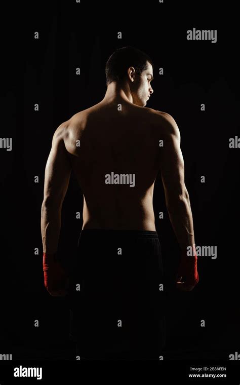 Male Boxer Posing His Powerful Back Against Black Background Stock