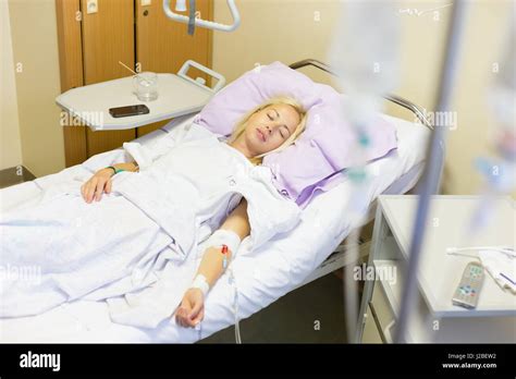 Bedridden Female Patient Lying In Hospital Bed Recovering After