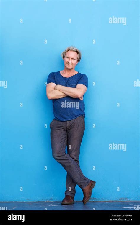 Full Length Portrait Of Confident Mature Man Standing With Arms Crossed