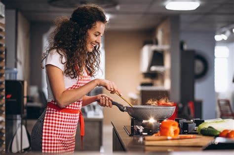 Chef mujer cocinar verduras en sartén Foto Gratis