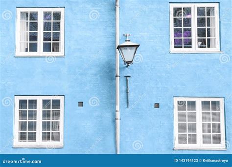 Light Blue Wall Street Lantern And Four White Windows Stock Image