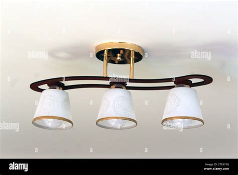 Chandelier With Three White Glass Plafonds And Brown Base Isolated On