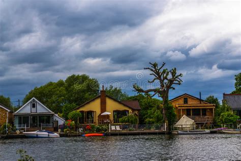 Wide River And Houses On The Shore Moored Boats Green Vegetation A