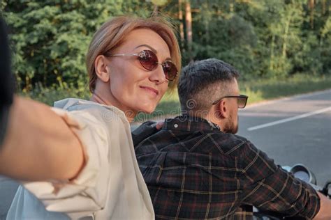 Middle Age Couple Riding A Motorcycle Having Fun And Taking Selfies