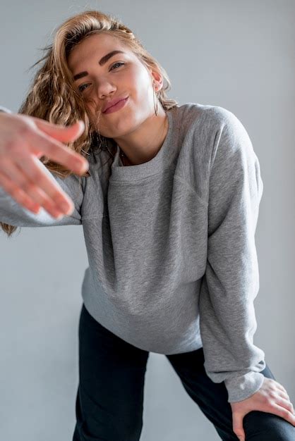 Portrait D Une Jeune Femme Blonde Debout Contre Le Mur Gris Photo Gratuite