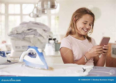 Young Girl Using Distracted By Phone While Ironing Stock Image Image