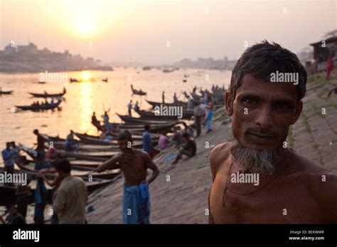 Man Standing Next To Rowboats On The Buriganga River In Dhaka