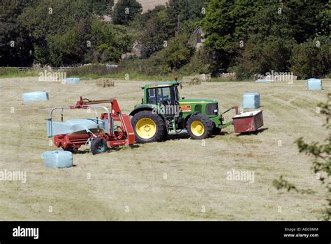 wrapping silage bales with plastic wrap Stock Photo - Alamy