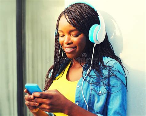 Portrait Of Happy Smiling Young African Woman In Headphones Listening